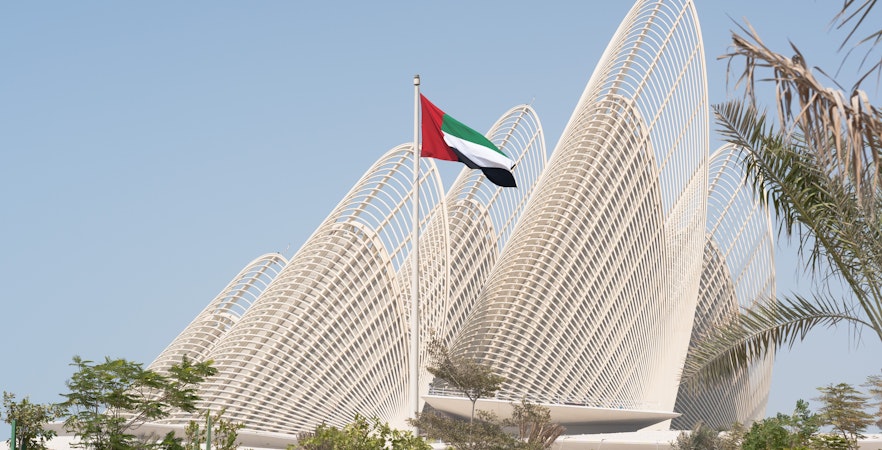 Zayed National Museum exterior with UAE flag in Abu Dhabi.