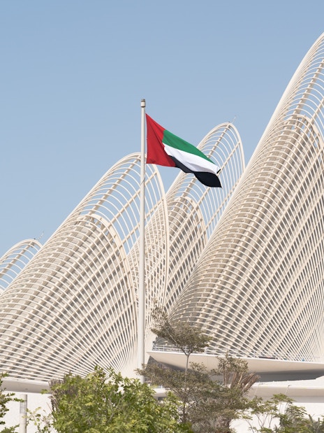 Zayed National Museum exterior with UAE flag in Abu Dhabi.