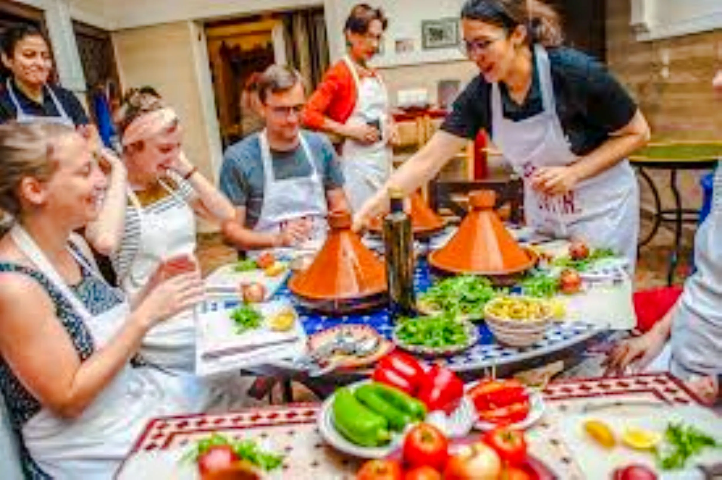 Participants in a Nairobi cooking class preparing traditional dishes with tagines and fresh ingredients.