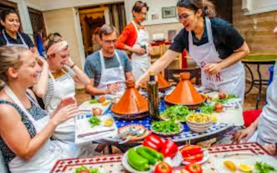 Participants in a Nairobi cooking class preparing traditional dishes with tagines and fresh ingredients.