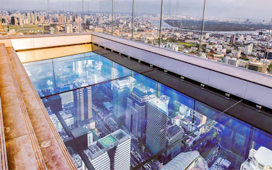 Mahanakhon SkyWalk glass floor with Bangkok cityscape view, Thailand.