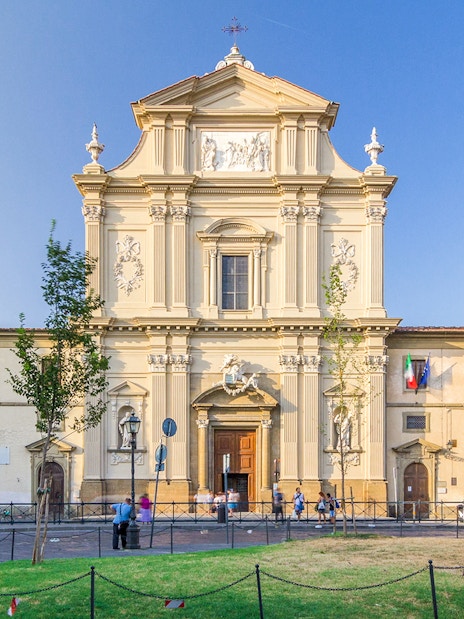 Facade of San Marco Church in Florence, Italy, with visitors and surrounding plaza.