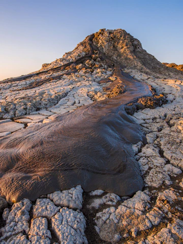 Active mud volcano in Gobustan desert, Azerbaijan with flowing mud and cracked earth.