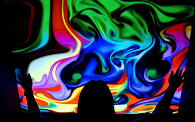 Visitor interacting with colorful digital display at DeJa Vu Museum exhibit.