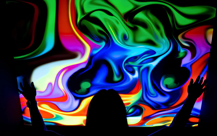 Visitor interacting with colorful digital display at DeJa Vu Museum exhibit.