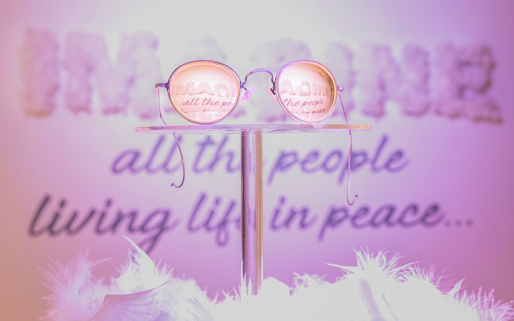 Round glasses reflecting "Imagine" lyrics at The Beatles Story exhibit.