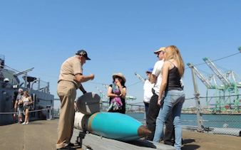 Group on ship deck during guided tour with crew stories and scavenger hunt access.