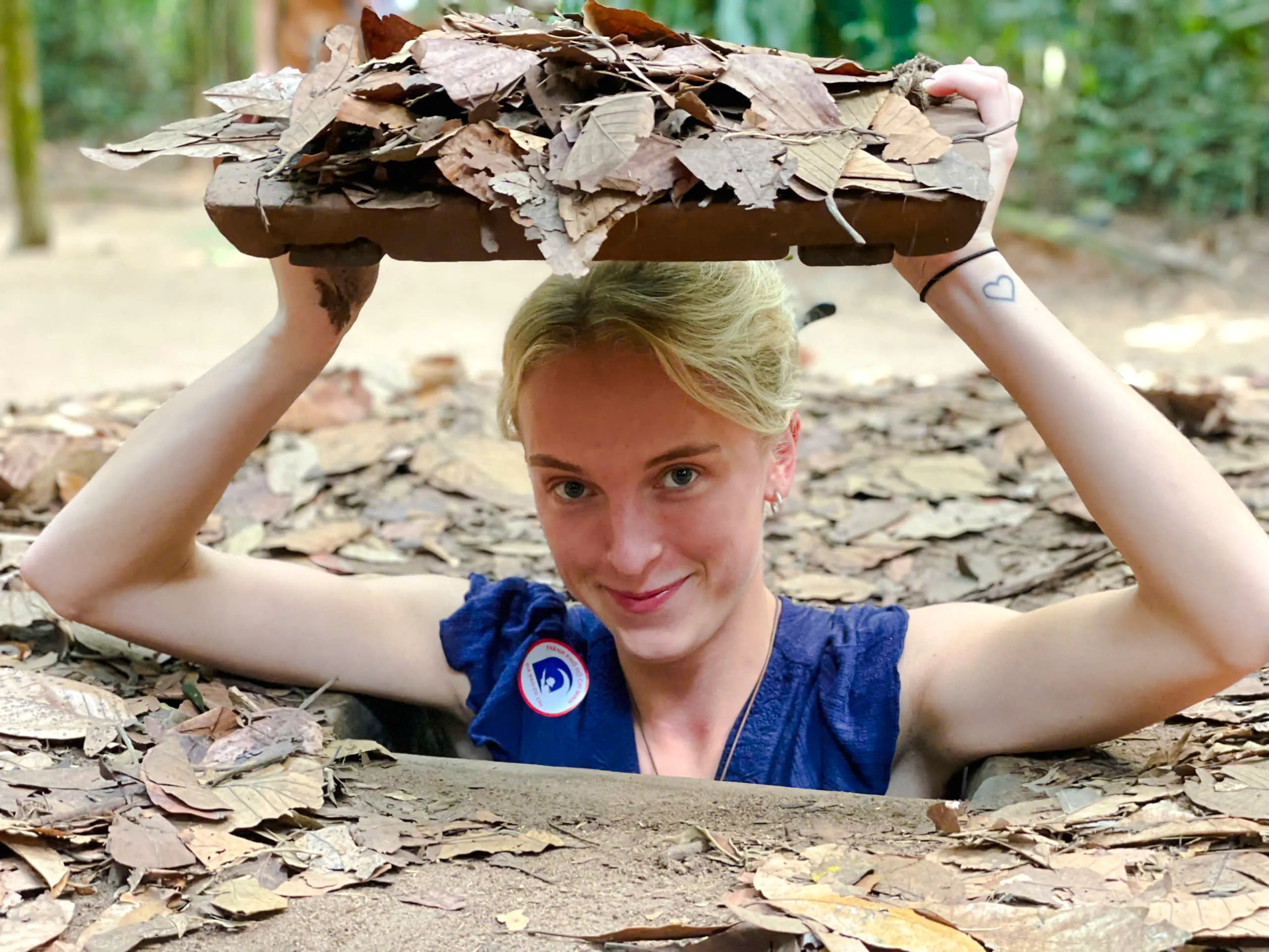 Person emerging from a hidden entrance at Cu Chi Tunnels, Tay Ninh.