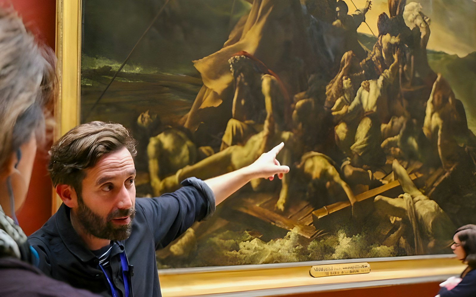 Tourists viewing The Raft of the Medusa painting in a museum.