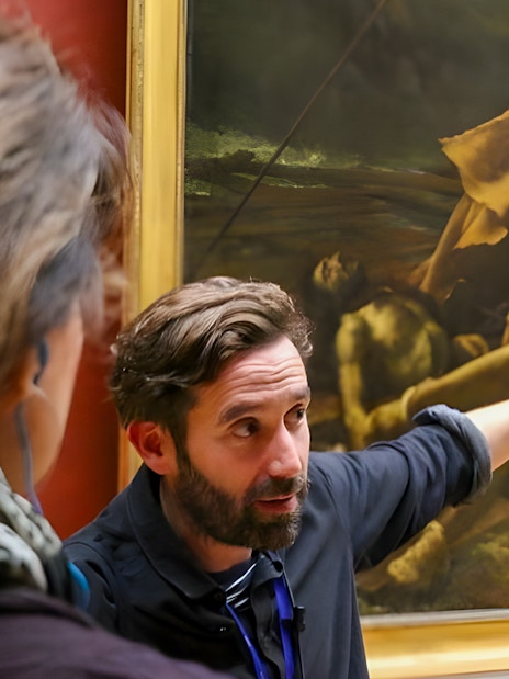 Tourists viewing The Raft of the Medusa painting in a museum.