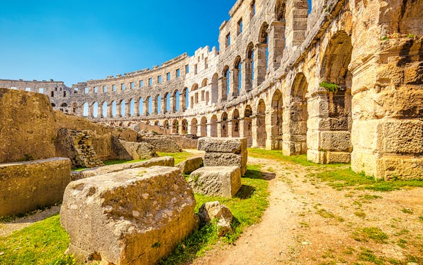 Roman Arena in Pula, Croatia with ancient stone arches and ruins.