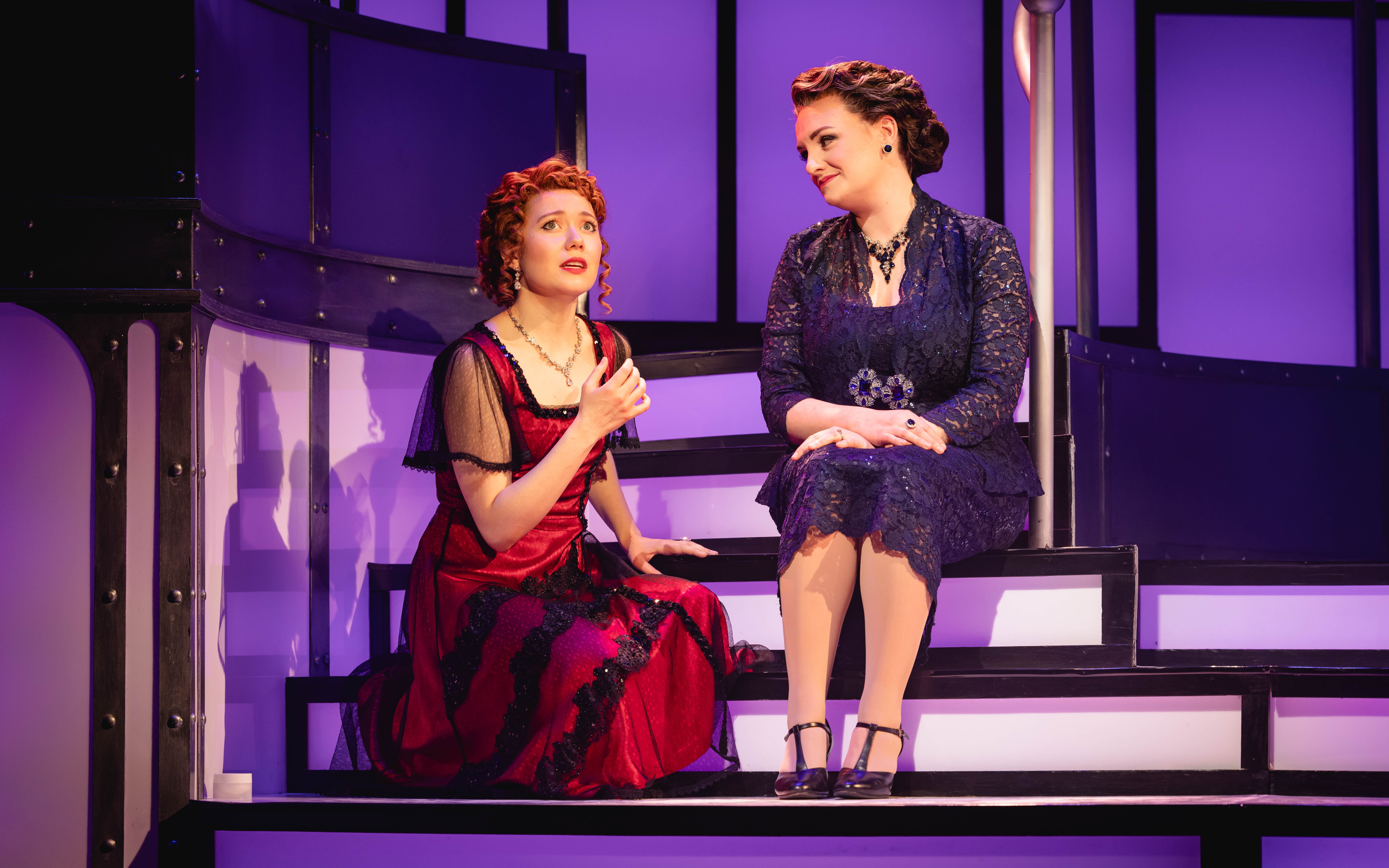 Stage scene from Titanique Westend with two performers on stairs.