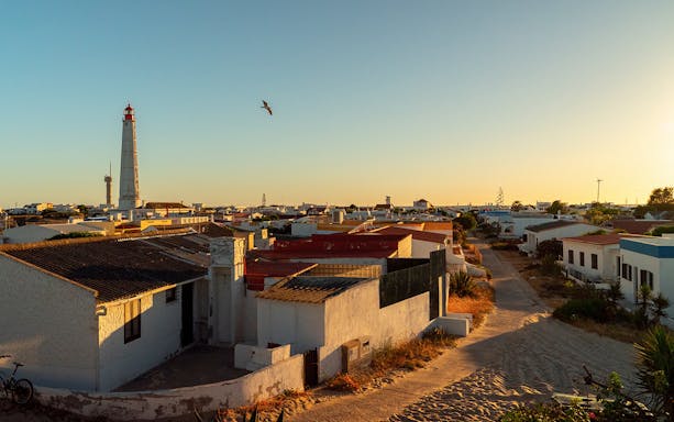 Lighthouse and village view during sunset on a private island tour.