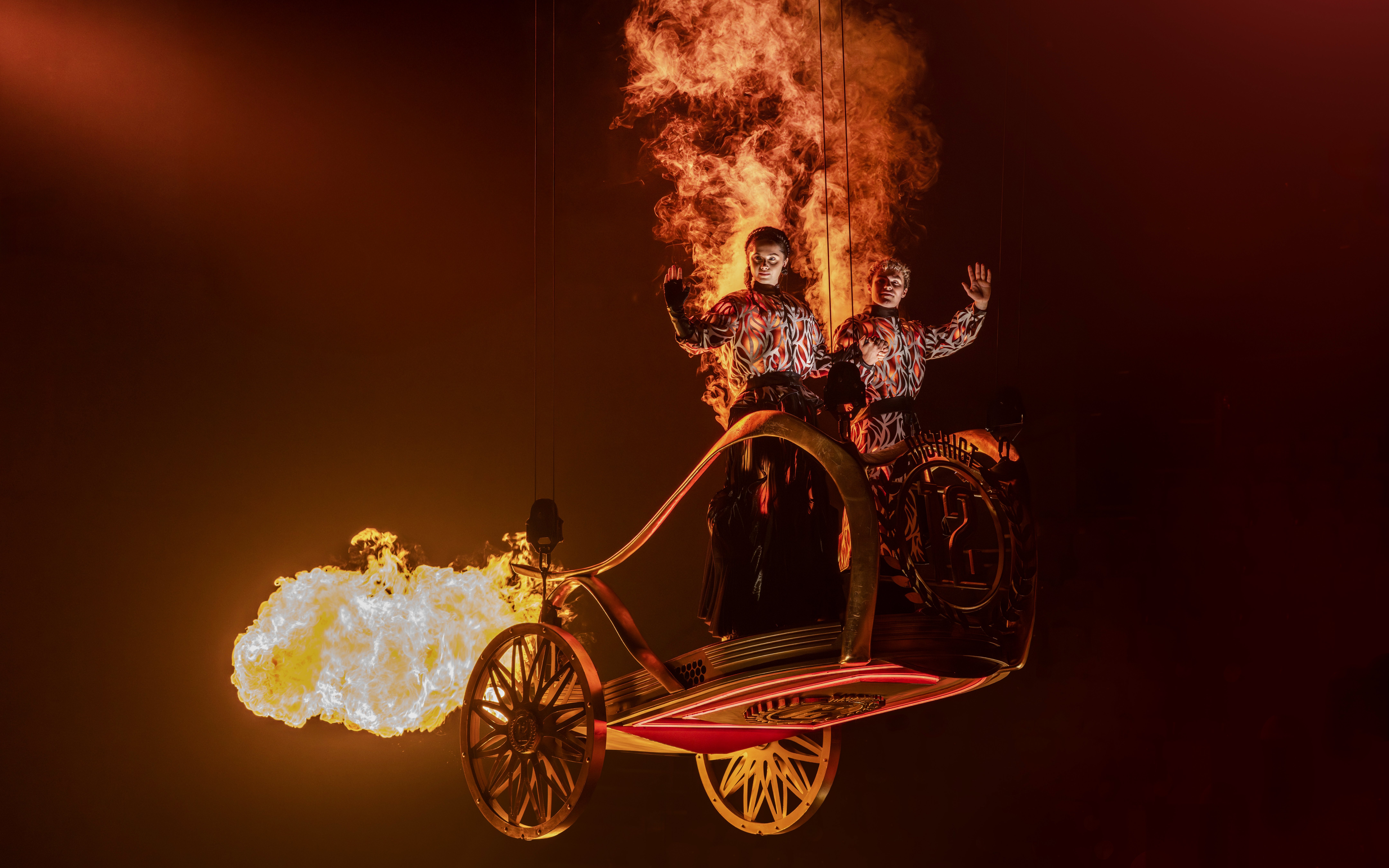 Performers in fiery costumes on stage during Hunger Games West End show.