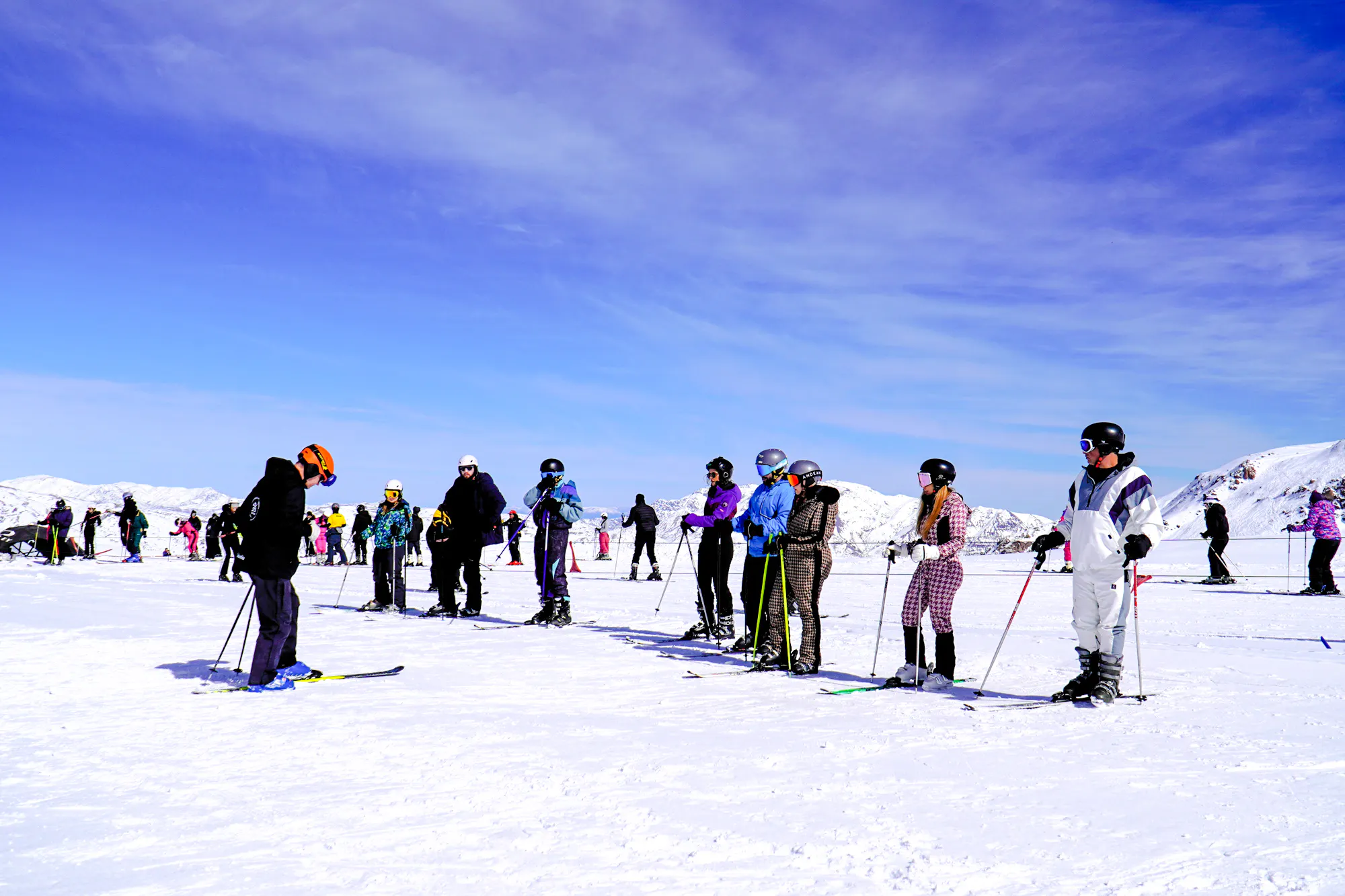 Skiers in line for a lesson at Valle Nevado, with snow-covered Andes mountains in the background, Santiago.