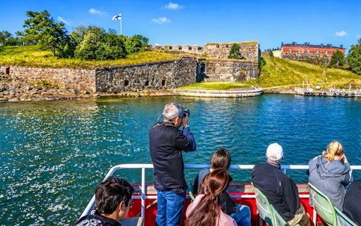 Guests on a boat viewing Suomenlinna fortress in Finland.