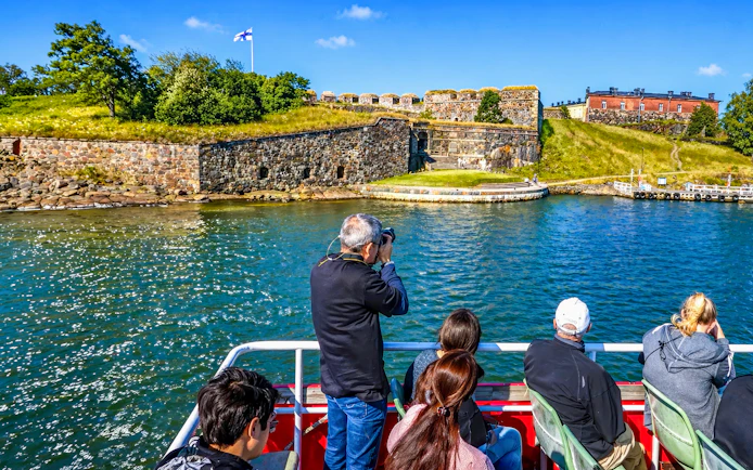 Guests on a boat viewing Suomenlinna fortress in Finland.