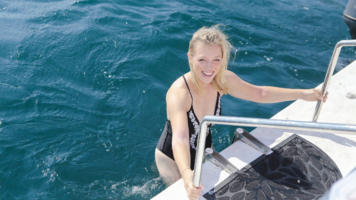 Female guests enjoying a boat tour on the Bay of Kotor, Montenegro, with scenic coastal views.