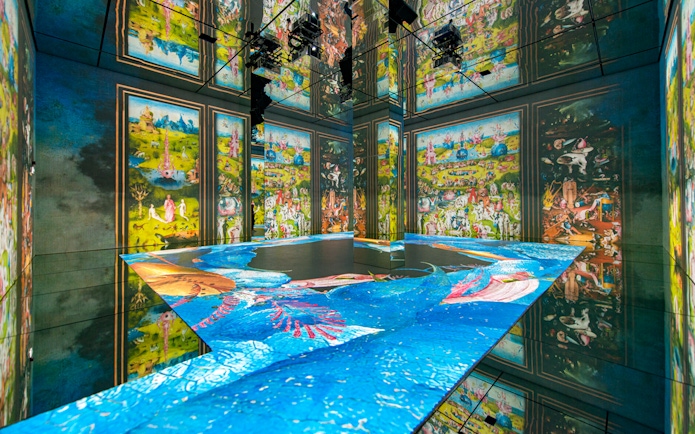 Beyond Reality gallery projections at Frameless London, featuring vibrant art displays on walls and floor.