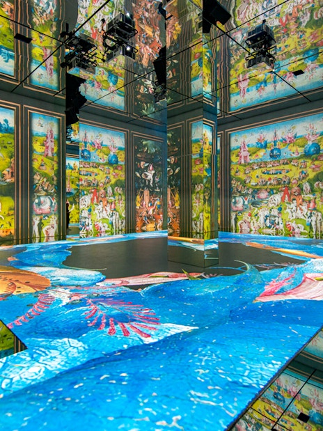 Beyond Reality gallery projections at Frameless London, featuring vibrant art displays on walls and floor.