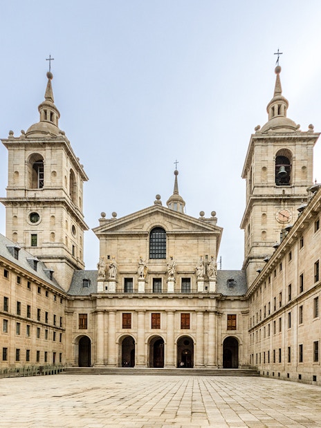 El Escorial's Court of Kings, featuring statues and twin towers in Madrid, Spain.