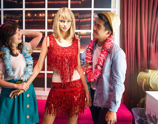 Visitors posing with a wax figure at Madame Tussauds Singapore.