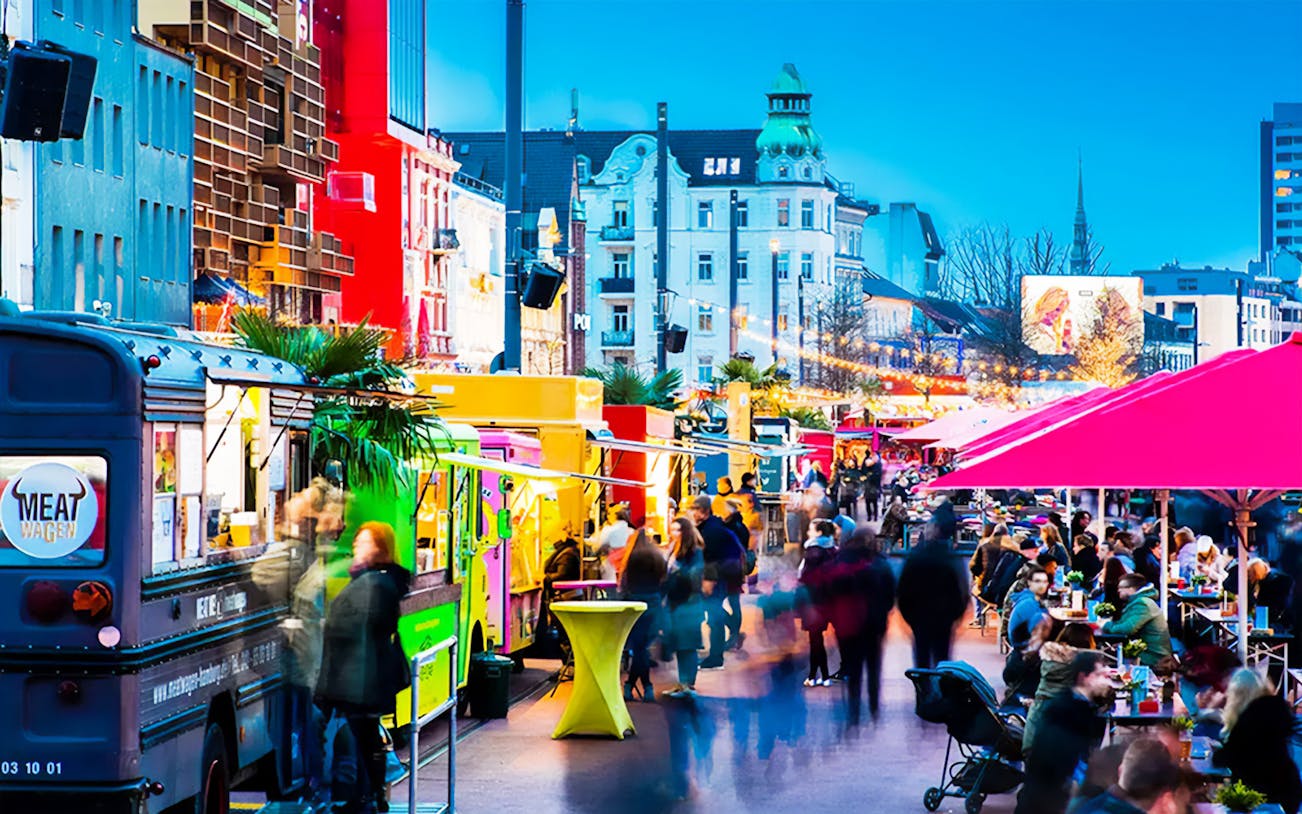 Food trucks and outdoor dining on a bustling street in St. Pauli, Hamburg.