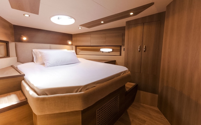 Interior cabin of Viktoriia Luxury Yacht with bed and wooden furnishings.