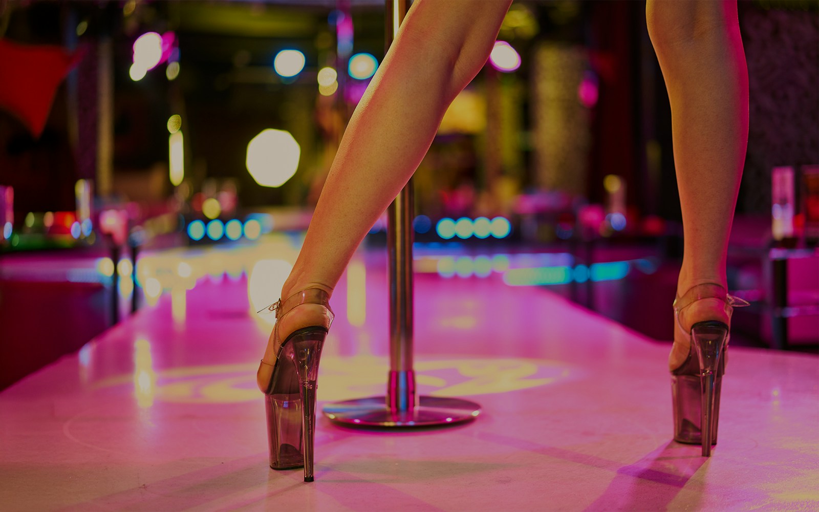 woman standing near dancing pole in strip club in amsterdam