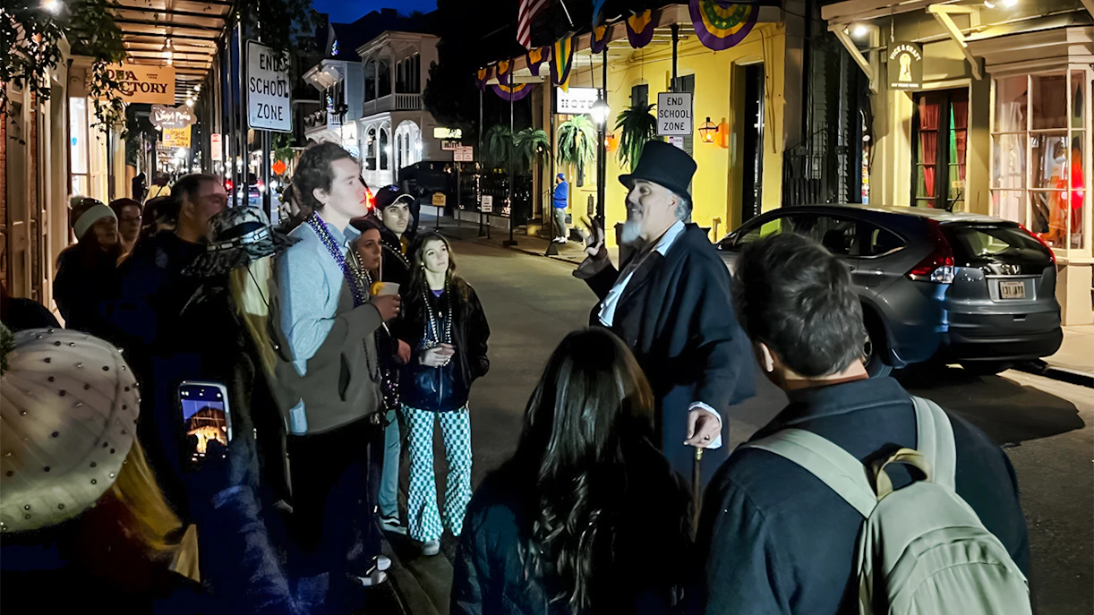 Guided tour group in New Orleans listening to a guide on a Haunted Ghost, Voodoo & Vampire Tour.