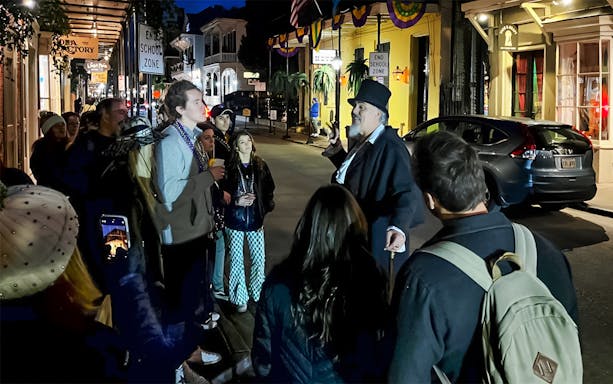 Guided tour group exploring haunted sites in New Orleans, featuring ghost, voodoo, and vampire stories.