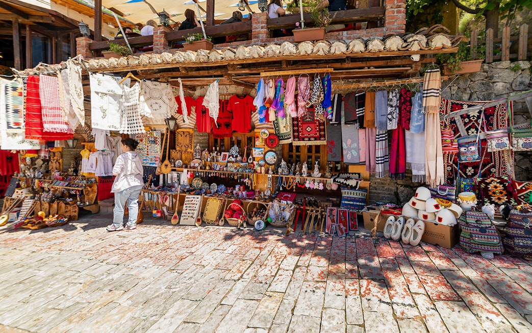 Market stall with traditional textiles and crafts in Kruja's old town market.