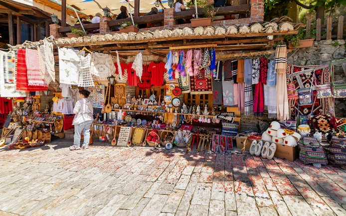 Market stall with traditional textiles and crafts in Kruja's old town market.