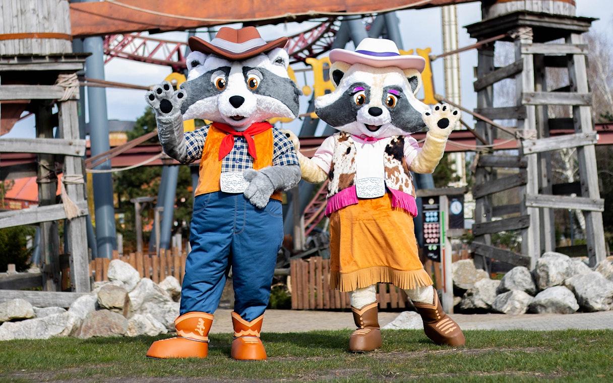 Raccoon mascots Randy and Rosie in cowboy outfits at Wild West Slagharen theme park.