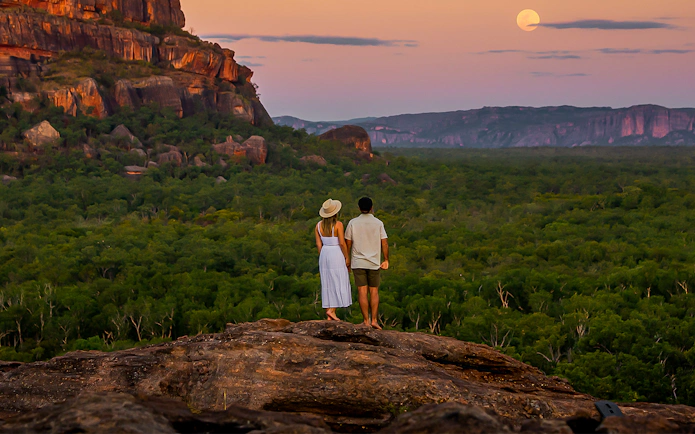 Couple overlooking Kakadu National Park landscape at sunset, Australia.