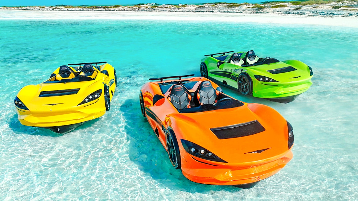 Three colorful Jet cars floating on clear water at Dubai shore.