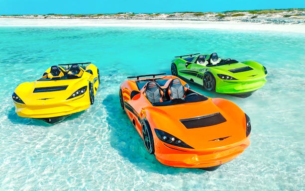 Three colorful Jet cars floating on clear water at Dubai shore.