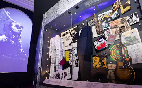 Exhibit of British music memorabilia including instruments and costumes at The British Music Experience.