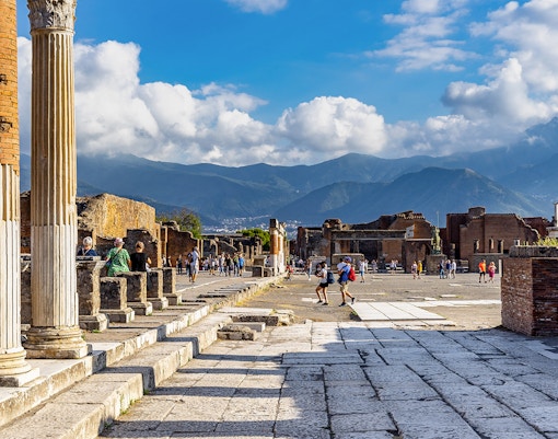 Pompeii Forum view from via del Foro with ancient columns and distant mountains.