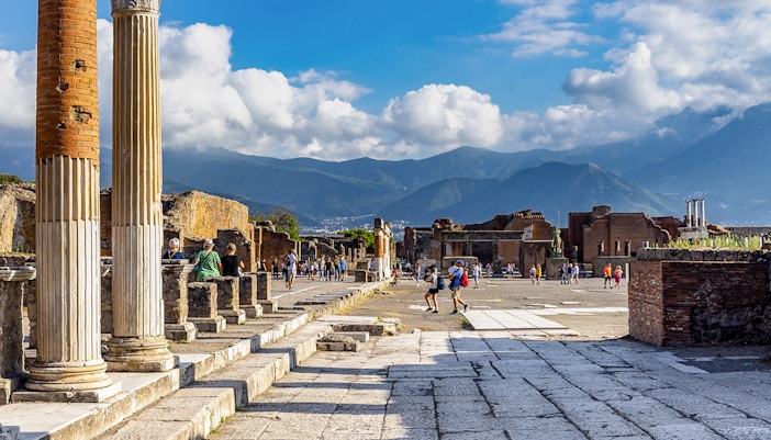 Pompeii Forum view from via del Foro with ancient ruins and Mount Vesuvius in the background.