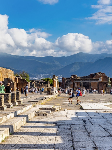 Pompeii Forum view from via del Foro with ancient columns and distant mountains.