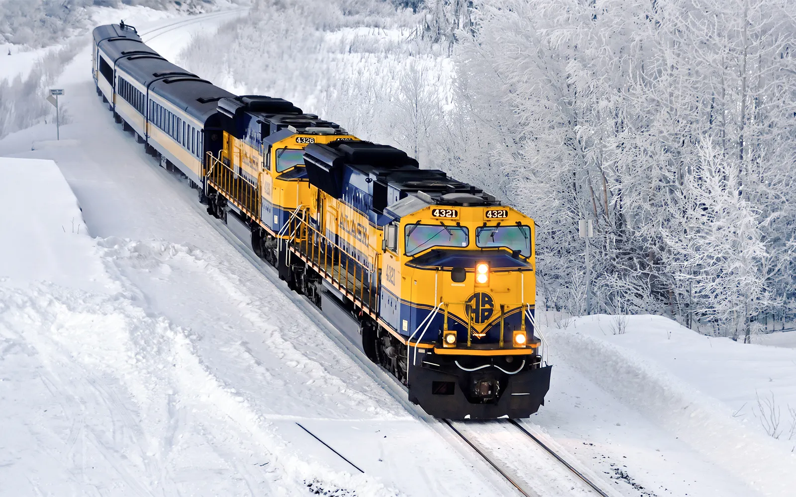 Aurora Winter Train traveling through snowy Alaskan landscape on the Alaska Railroad.