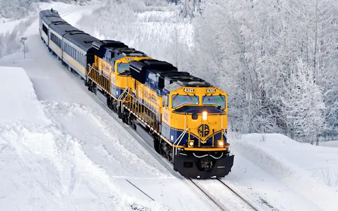 Aurora Winter Train traveling through snowy Alaskan landscape on the Alaska Railroad.