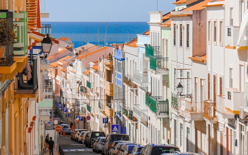 Traditional street with colorful buildings in Nazaré, Centro, Portugal, leading to the ocean.