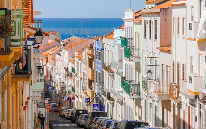 Traditional street with colorful buildings in Nazaré, Centro, Portugal, leading to the ocean.