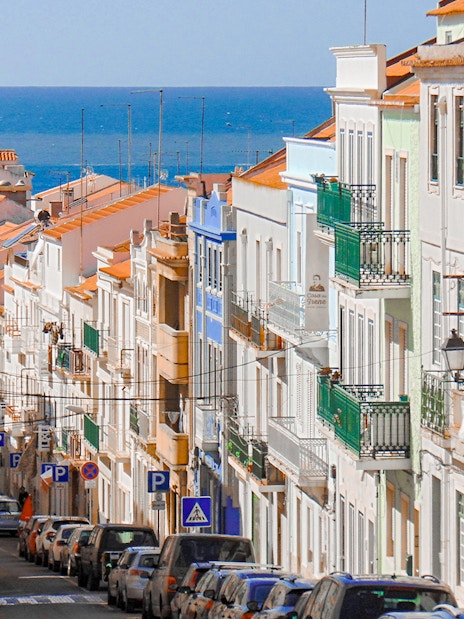 Traditional street with colorful buildings in Nazaré, Centro, Portugal, leading to the ocean.
