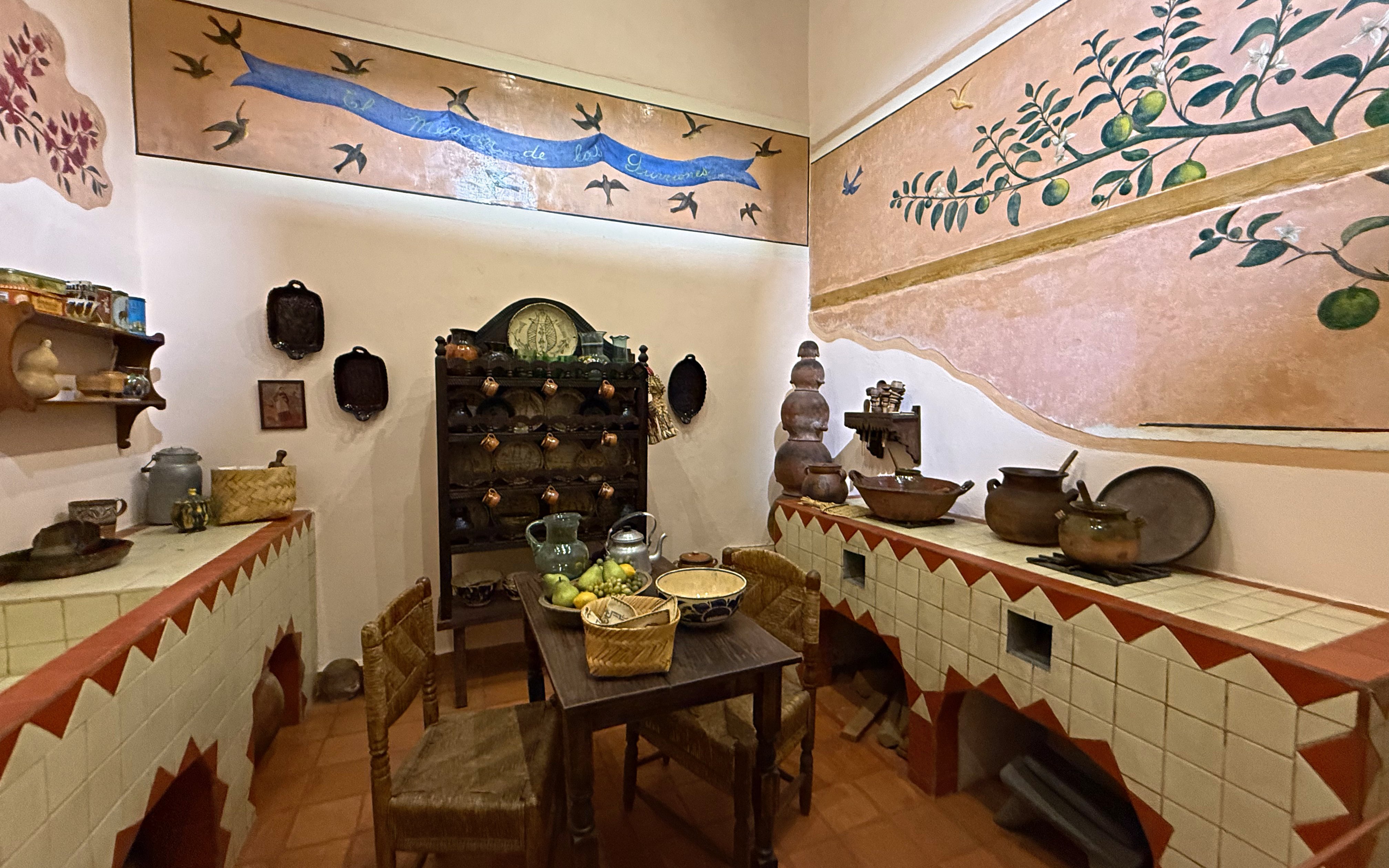 Frida Kahlo Museum kitchen with traditional Mexican pottery and wall art at La Casa Roja.