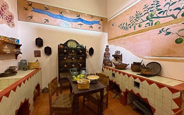 Frida Kahlo Museum kitchen with traditional Mexican pottery and wall art at La Casa Roja.