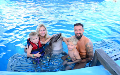 Family posing with dolphin at Egypt Dolphin World, Hurghada.