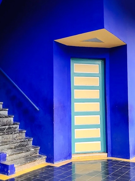 Jardin Majorelle interior with blue walls, stairs, and potted plants in Marrakech, Morocco.